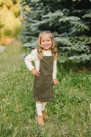 Green corduroy dress for babies, stylish and comfortable, shown from angle 4. Perfect for any occasion.