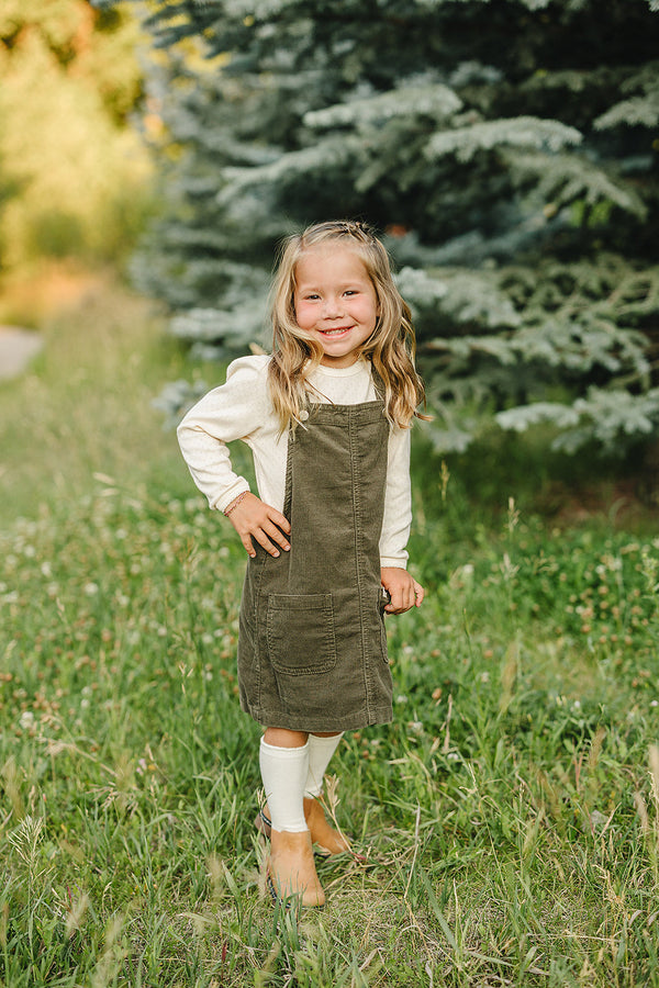 Green corduroy dress for babies, stylish and comfortable, shown from angle 4. Perfect for any occasion.