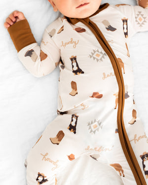 Bedtime Buckaroo Zipper Lounger for babies, cozy loungewear in playful design, shown from angle 3.