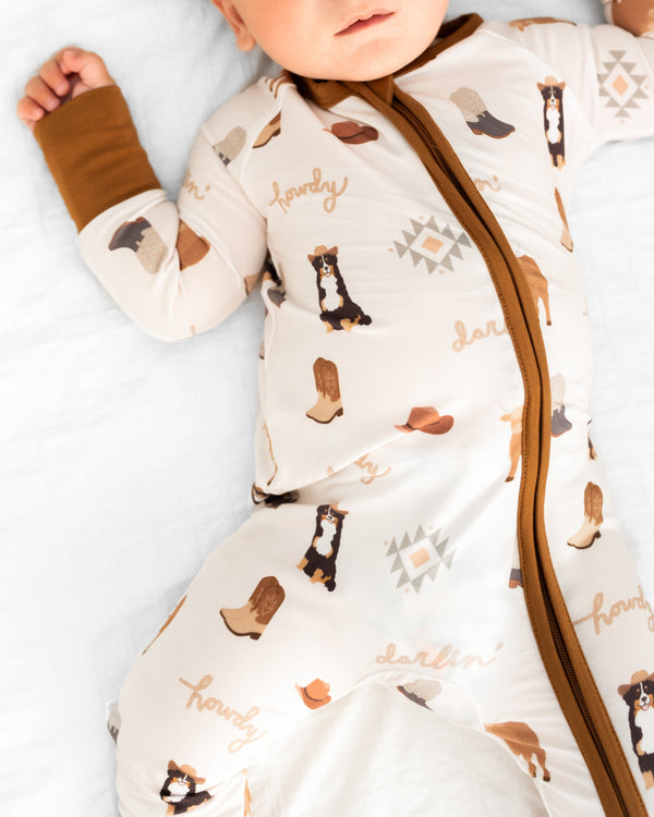 Bedtime Buckaroo Zipper Lounger for babies, cozy loungewear in playful design, shown from angle 3.