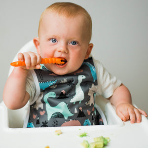 Dinosaur Drawing Bapron for babies, angled view showcasing fun design and practical use for mealtime messes.