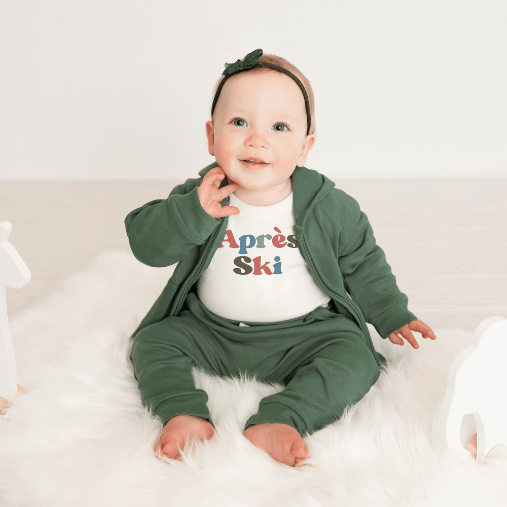 Long sleeve graphic bodysuit for babies, featuring an apres ski design, perfect for winter outings.