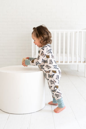 Social Butterfly Zipper Lounger for babies, cozy loungewear in playful design, showcased from angle 4.