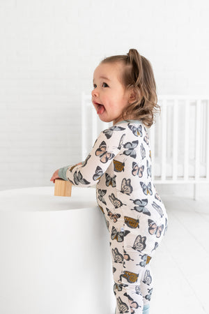 Social Butterfly Zipper Lounger for babies, cozy loungewear in playful design, shown from angle 5.