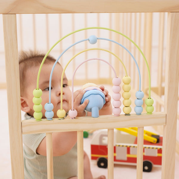 Wooden baby playpen with mirror and whiteboard, foldable 63" x 63", Montessori sensory play yard, angle view.