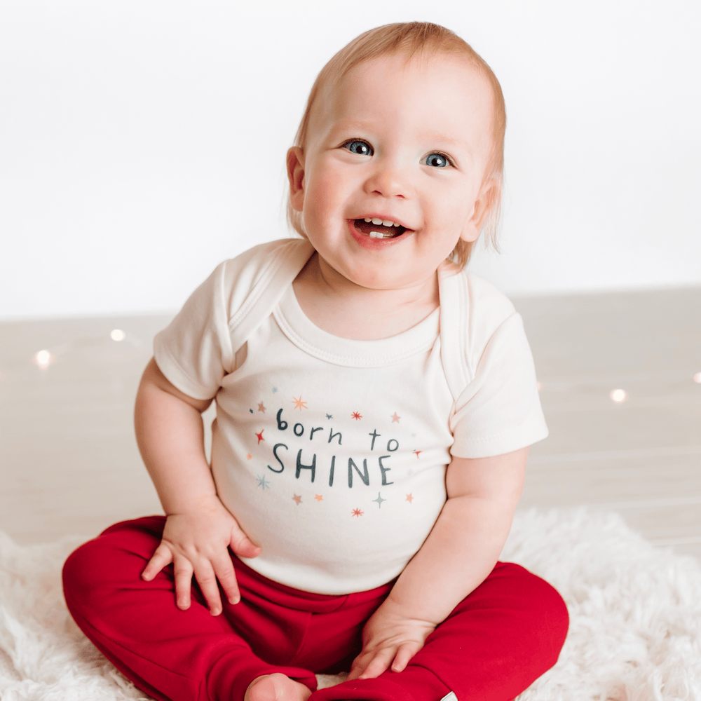 Graphic bodysuit "Born to Shine" for babies, short sleeve design, perfect for stylish and comfortable playtime.
