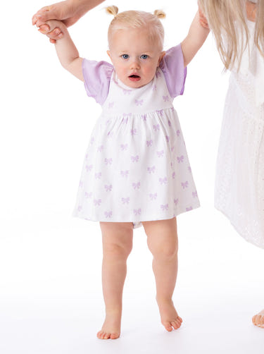 Organic cotton Alice ruffled dress with bow for babies and toddlers, perfect for special occasions.
