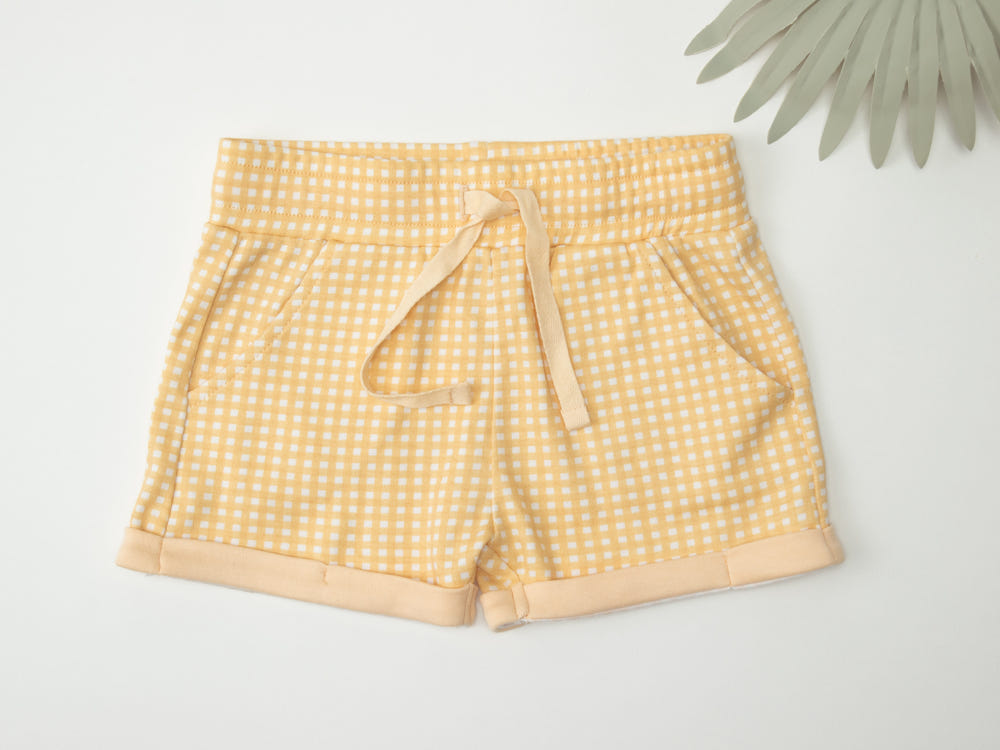 Organic cotton baby shorts in butter gingham pattern, perfect for comfort and style.