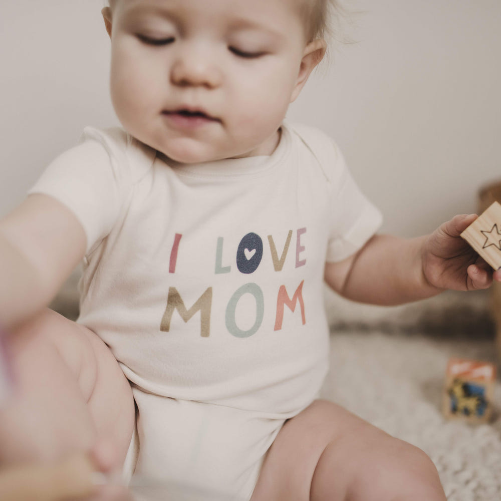 Graphic bodysuit featuring "Love Mom" design for babies, perfect for stylish and comfortable wear.