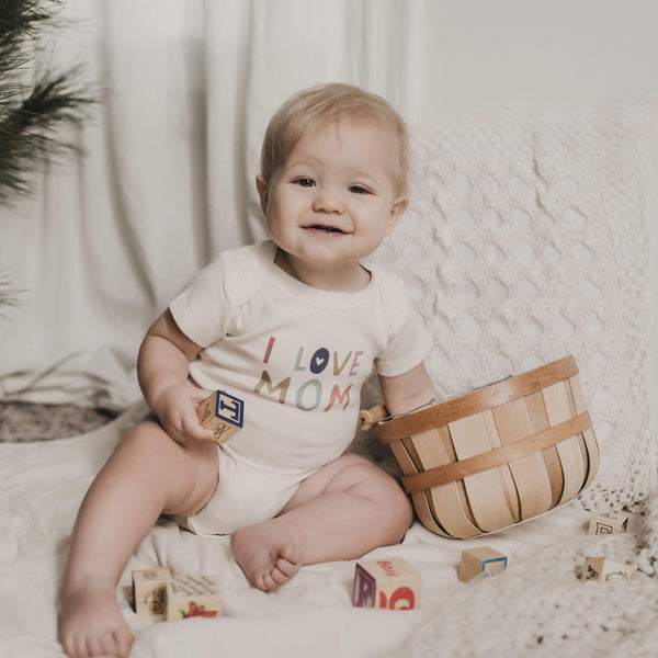 Graphic bodysuit "Love Mom" for babies, short sleeve, angle view showcasing cute design.