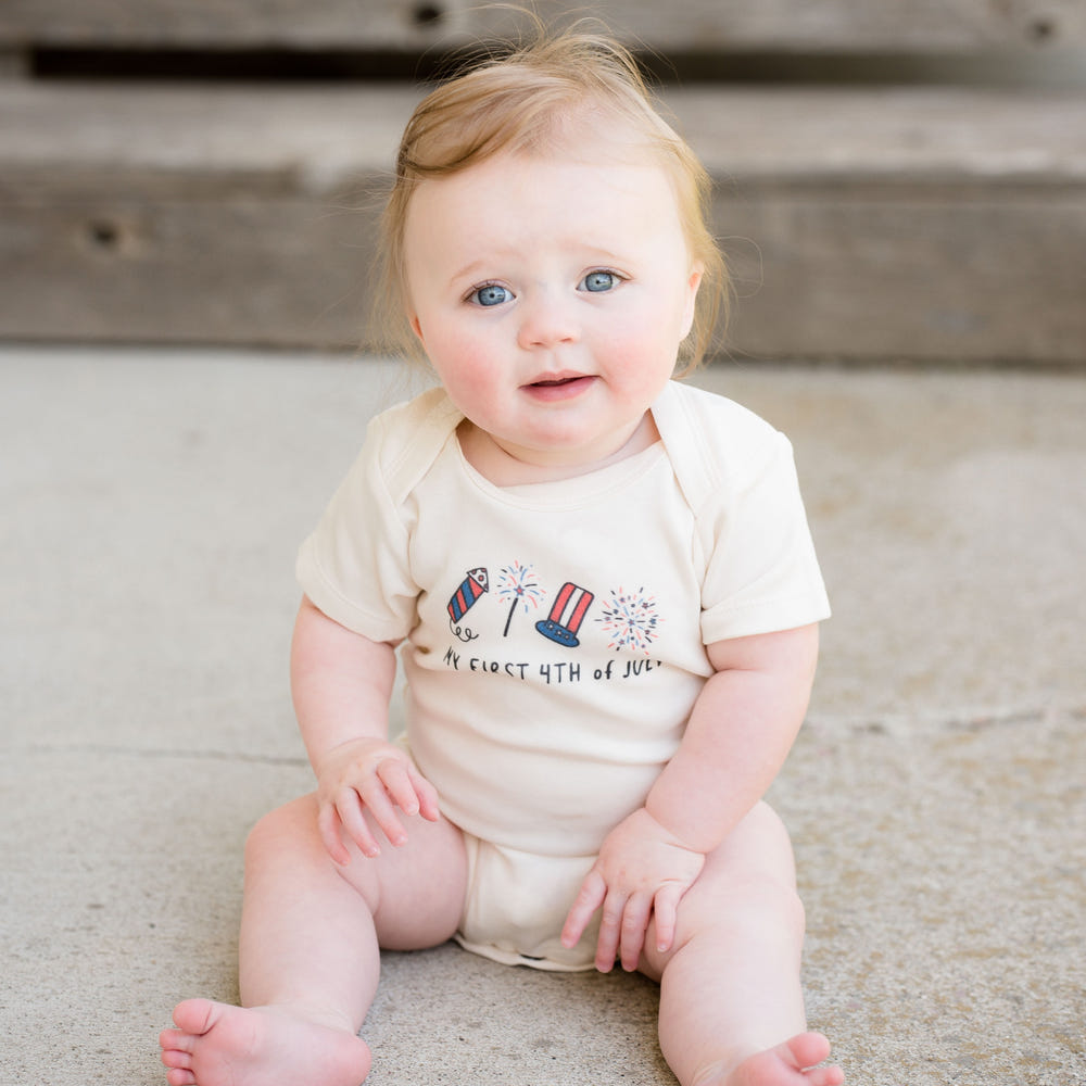 Graphic bodysuit for babies featuring "My First 4th of July" rocket design, perfect for celebrating Independence Day.