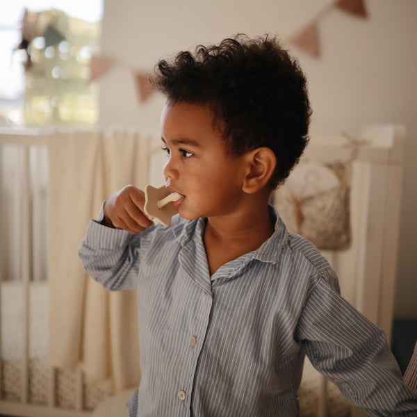 "Star Training Toothbrush for babies, angled view showcasing its soft bristles and ergonomic design for easy grip."