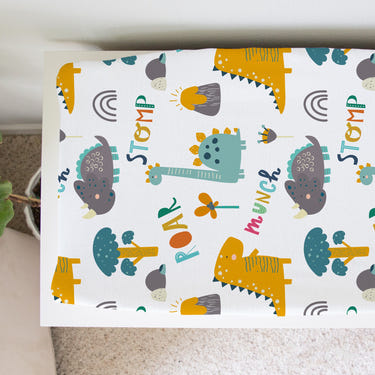 Dinoland changing pad cover for babies, featuring a playful dinosaur design, perfect for nursery decor.