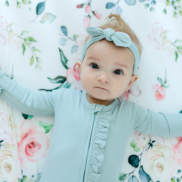 Peach floral fitted crib sheet at angle 7, perfect for adding a touch of charm to your baby's nursery decor.