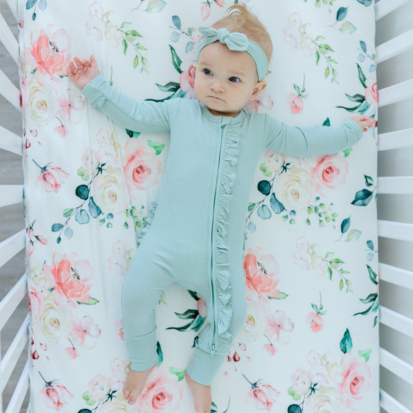 Peach floral fitted crib sheet at angle 8, perfect for stylish nursery decor.