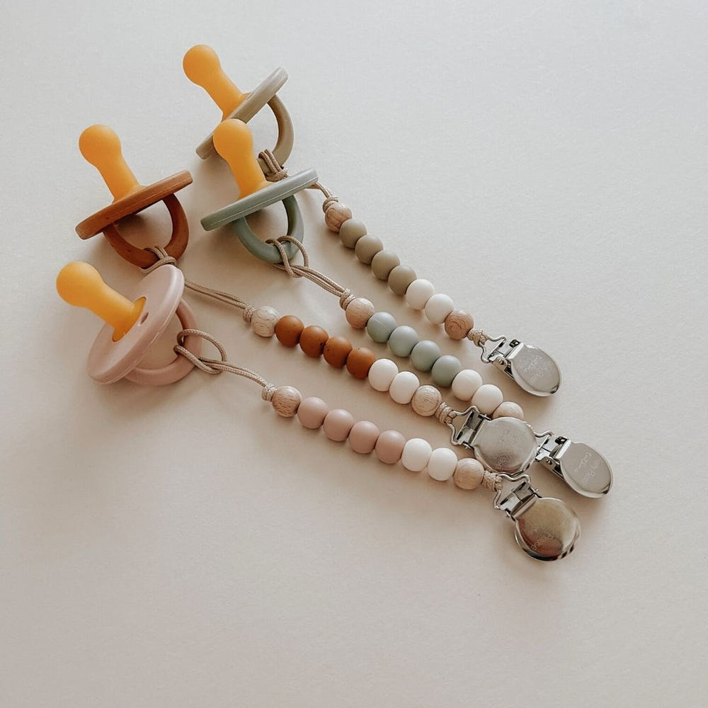 Modern moss green pacifier for babies, designed for comfort and style.