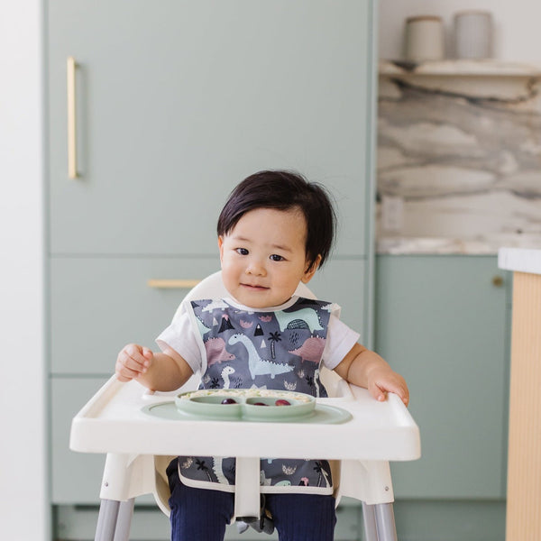 Dinosaur Drawing Bapron for babies, angled view showcasing fun design and practical use for mealtime messes.