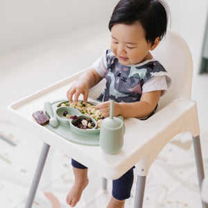 Dinosaur Drawing Bapron for babies, angled view showcasing fun design and practical use for messy mealtime activities.