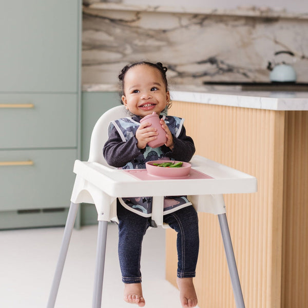 Dinosaur Drawing Bapron for babies, angled view showcasing fun design and practical use for mealtime messes.