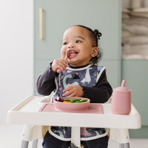 Dinosaur Drawing Bapron for babies, angled view showcasing fun design and practical use for mealtime messes.