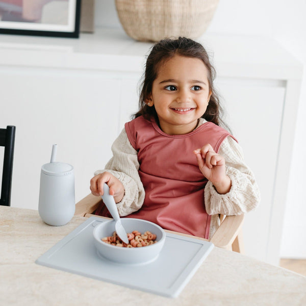 Solid blush minimalist bapron for babies, showcasing a stylish and practical design from angle 2.