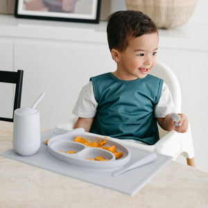 Solid Pine Minimalist Bapron for babies, angled view showcasing its stylish and functional design.