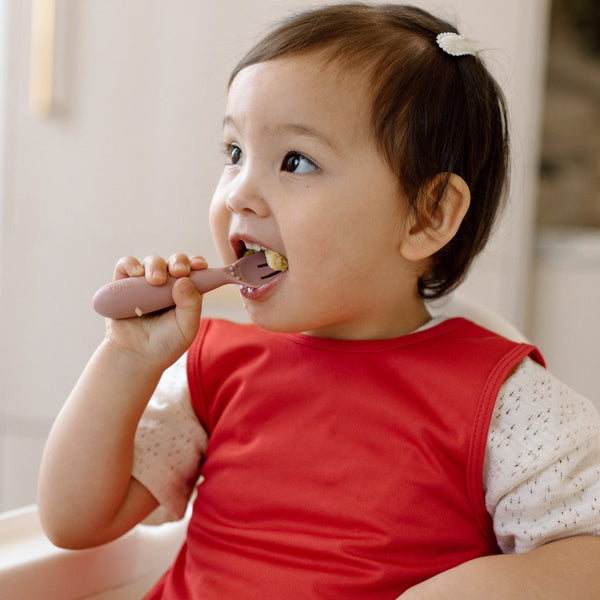 Solid candy apple red minimalist bapron for babies, shown from angle 2, perfect for mealtime messes.