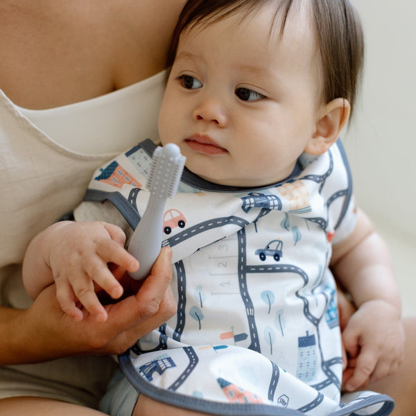 Tiny Town Bapron for babies, angle view showcasing its colorful design and practical features for mealtime messes.