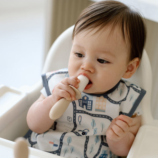 Tiny Town Bapron for babies, angle view showcasing colorful design and practical features for mealtime messes.