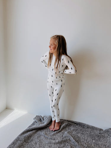 Bamboo two-piece pajamas in white with black lightning bolt design for babies. Soft, stylish, and comfortable sleepwear.