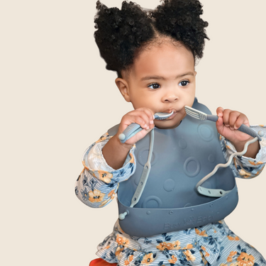 Silicone Travel Tether Bib with utensils for mess-free feeding on-the-go. Ideal for babies and toddlers.