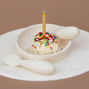 "First Foods Set for babies, featuring colorful utensils and bowls at a 23-degree angle."