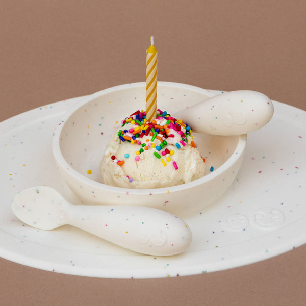 "First Foods Set for babies, featuring colorful utensils and bowls at a 23-degree angle."