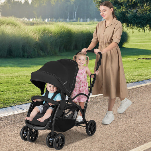Foldable twin tandem stroller in black, featuring adjustable handlebar for sit and stand convenience.