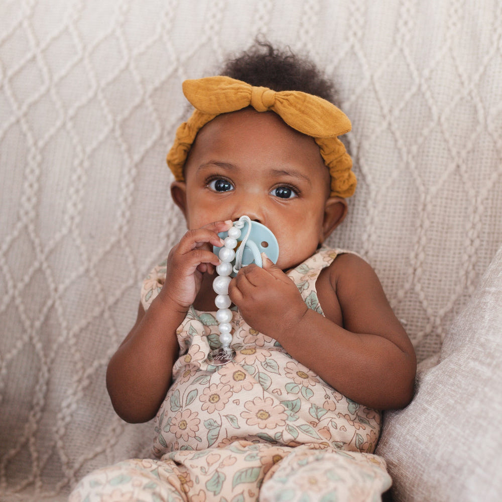 Strand Clip Pearl pacifier clip for babies, stylish and functional accessory to keep pacifiers close and clean.