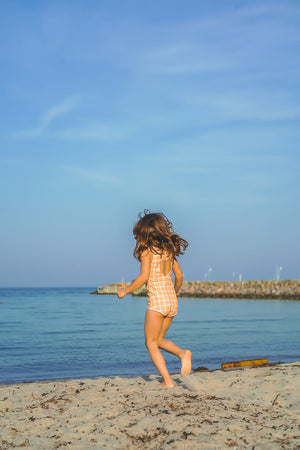 Sweetheart 1 Piece Swimsuit in Buckwheat Plaid, UPF protected, eco-friendly, angle view. Perfect for baby swimwear.