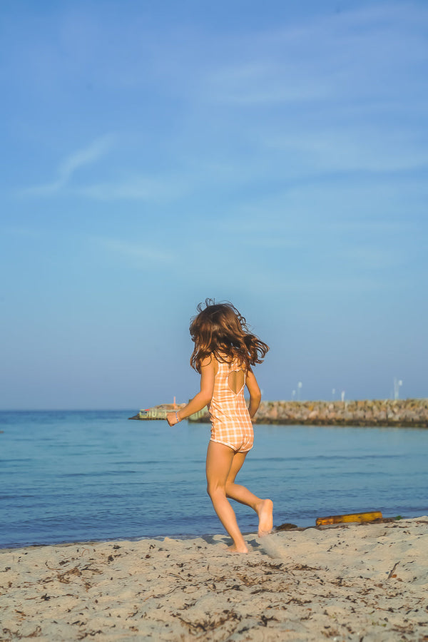 Sweetheart 1 Piece Swimsuit in Buckwheat Plaid, UPF protected, eco-friendly, angle view. Perfect for baby swimwear.