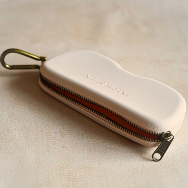 Soft silicone Zip + Go Case in sand color, perfect for baby accessories and seasonal wear. Angle 2 view.
