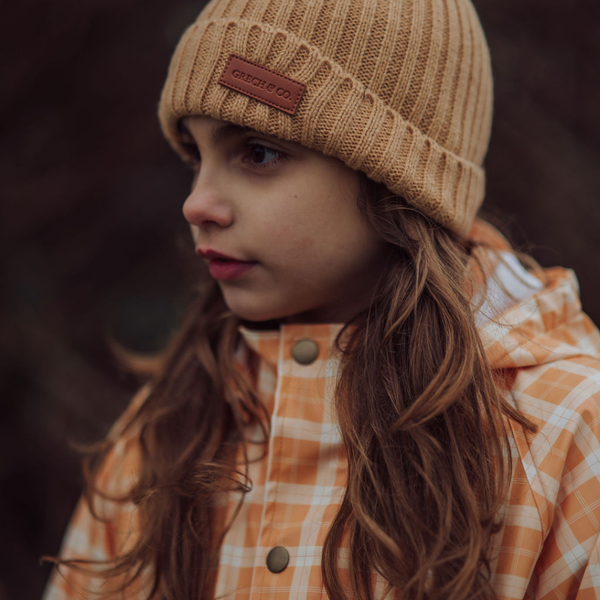 Knit beanie in buckwheat color, wide rib design, perfect for babies. Angle 2 view showcasing texture and style.