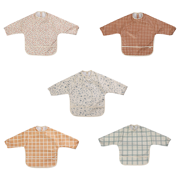 Buckwheat plaid smock bib for babies, angled view showcasing its stylish design and practicality.