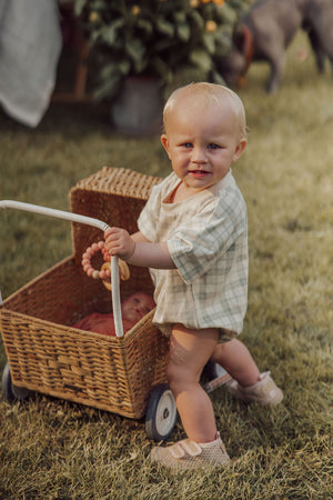 Organic cotton bubble romper in fern plaid, angle view showcasing soft, stylish baby clothing.