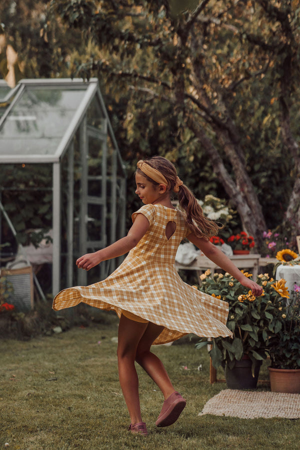 Sweetheart Twirl Dress in Buckwheat Plaid, organic cotton jersey, perfect for baby swimwear. Angle 2 view.
