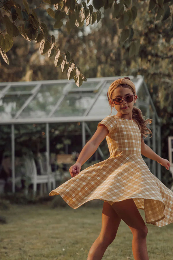 Sweetheart Twirl Dress in Buckwheat Plaid, organic cotton jersey, perfect for baby swimwear. Angle 4 view.