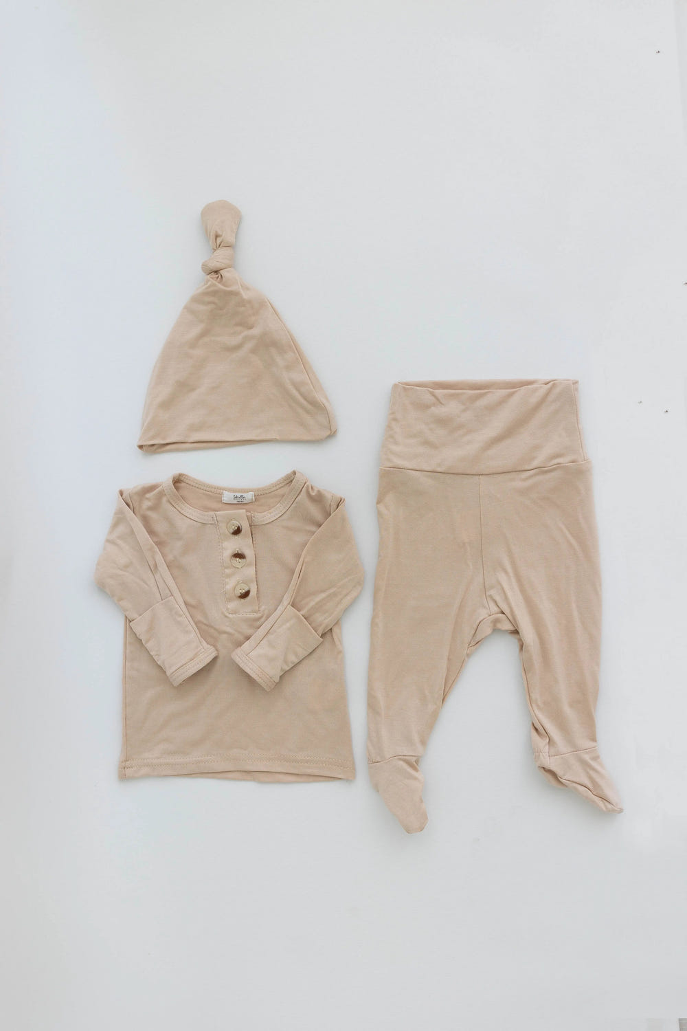 Gender-neutral newborn top and bottom outfit set in sand color, perfect for stylish and comfortable baby wear.