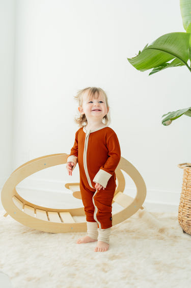 Rust ribbed romper for babies, featuring soft fabric and stylish design, perfect for comfort and playtime.