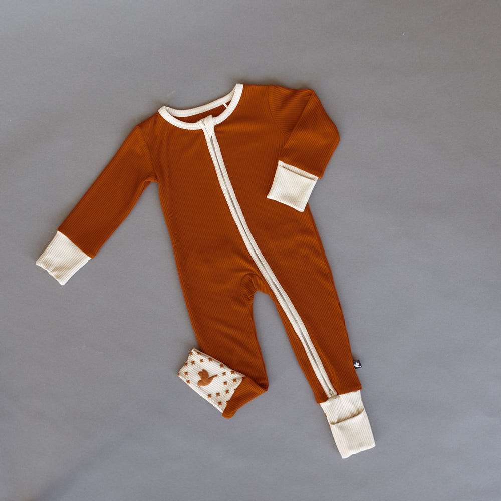 Rust ribbed romper for babies, featuring soft fabric and stylish design, perfect for comfort and playtime.