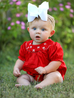 Girls red romper with bow smocking and embroidery, perfect for stylish baby outfits.
