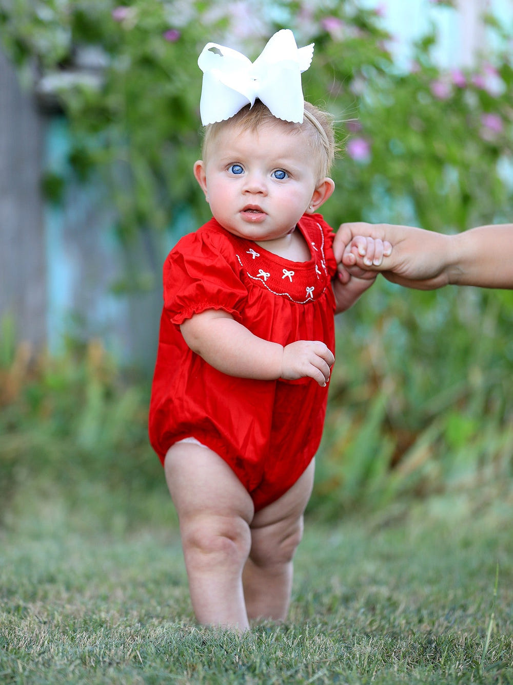 Girls red romper with bow smocking and embroidery, perfect for stylish baby outfits.