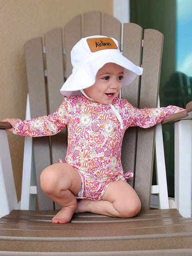 Pink seashell rash guard swimsuit for babies, perfect for sun protection and fun in the water.