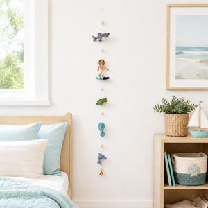 Felt surfer garland hanging on a nursery wall showing shark, turtle, seahorse, and dolphin figures in a row